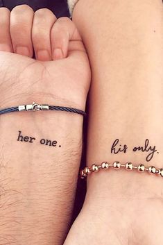 two people with matching tattoos on their arms holding hands and the words her one, his only