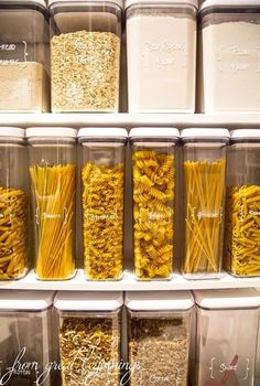 the shelves are filled with different types of pasta in plastic containers and labeled labels on them