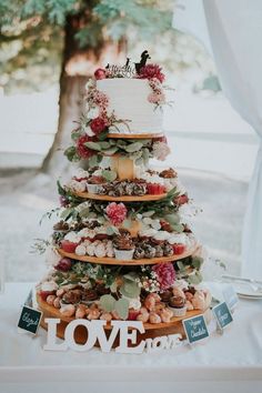 a wedding cake is stacked on top of each other with flowers and leaves around it