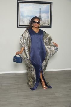 Look stylish and elegant in this Navy Blue and Gold Kaftan Dress. The rich navy color is complemented by beautiful gold patterns on the sides and sleeves, making this dress perfect for any special event. The loose, flowing design allows for comfort while still looking chic. The matching handbag adds a polished touch to the outfit, making you stand out with confidence. Features: Material: Soft and comfortable fabric with gold accents. Design: Navy blue with gold patterns on the sides and sleeves. Elegant Blue Kaftan For Formal Occasions, Elegant Blue Silk Kaftan, Blue Party Dress With Kimono Sleeves, Gold Long Silk Dress, Long Gold Silk Dress, Bubu Dress, Navy Blue And Gold, Flow Design, Outfit Making