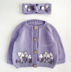 a purple knitted sweater and matching headband with flowers on the front is shown