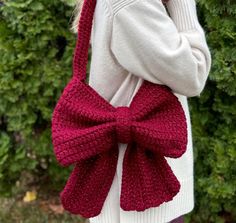 a woman wearing a red knitted bow bag