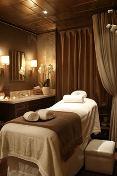 a spa room with towels on the bed and candles lit up in front of it