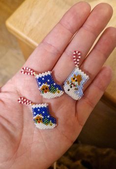 someone is holding three pieces of bead art