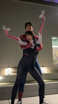 a man and woman dressed in spider - man costumes are posing for the camera with their arms around each other