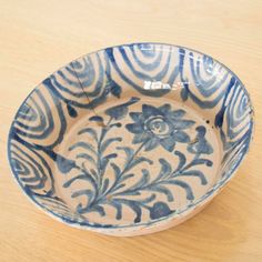 a blue and white bowl sitting on top of a wooden table