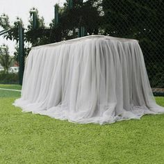 a table covered with a white cloth in the grass