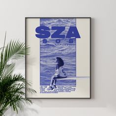 a blue and white poster hanging on the wall next to a potted palm tree