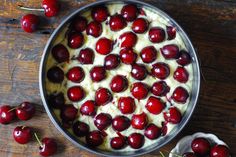 cherries and cream in a metal bowl on a wooden table