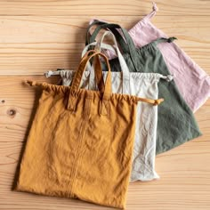 five different colored bags sitting on top of a wooden floor