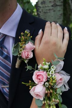 a man and woman wearing boutonnieres with pink flowers on their lapels