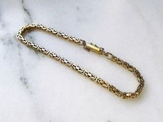 "This is a 14K yellow gold solid byzantine chain bracelet.  The bracelet is 2.9mm wide and measures 7 5/8\" long.  The box clasp is secure, but a portion of the safety chain is missing and not functioning.  The bracelet weighs 12.4 grams / 8.0dwt.  The bracelet is stamped 14K & Aurea. This is a vintage, previously owned bracelet.  Therefore, light wear can be expected.  There is no visible damage." Byzantine Chain, Real Jewelry, Safety Chain, Box Clasp, Chain Link Bracelet, Link Bracelets, Chain Bracelet, Chain Link, Gold Bracelet