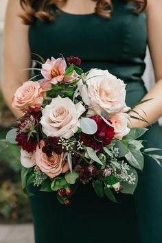 a bridesmaid holding a bouquet of flowers in her hands and wearing a green dress