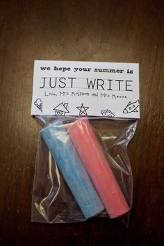 two colored candles sitting on top of a plastic wrapper next to a sign that says, we hope your summer is just write