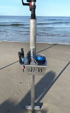 a metal pole with various items on it at the beach