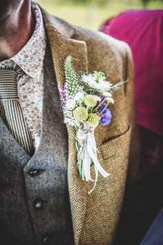 a man wearing a suit and tie with a boutonniere on his lapel