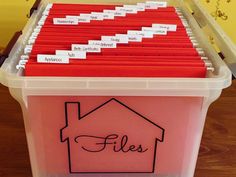 a plastic container filled with files on top of a wooden table