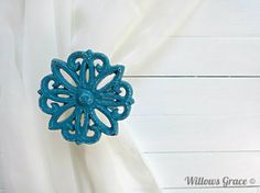 a close up of a curtain with a blue flower on it's center piece