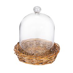 a glass clochet with a wooden base and wicker basket underneath it on a white background