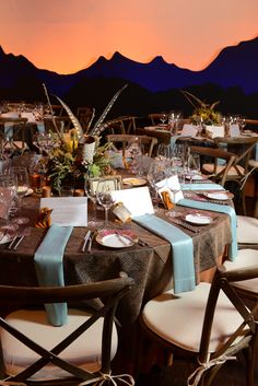 the table is set with place settings for two people to sit at, and there are mountains in the background