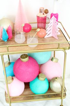 a gold cart filled with lots of different colored ornaments