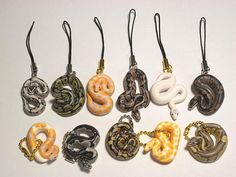 six different types of snake pendants on black cords