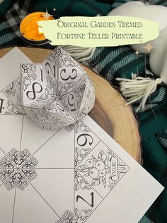 the original garden themed fortune teller printable is displayed on a table with other items