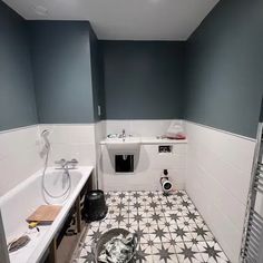 an empty bathroom with blue walls and white tiles on the floor is pictured in this image