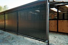 a fenced off area with a wooden building in the background and dirt on the ground