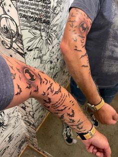 two people with tattoos on their arms standing next to each other