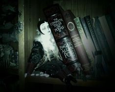 a shelf filled with books and dolls on top of each other in a dark room