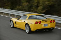 a yellow sports car driving down the road