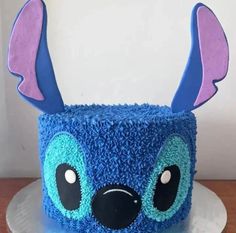 a cake decorated with blue frosting and pink ears