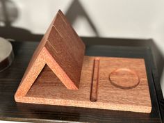 a wooden object sitting on top of a table next to a cup and saucer