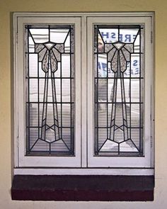 two stained glass windows in the side of a building