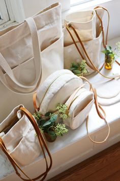 three white bags sitting on top of a window sill