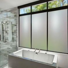 a bathroom with a large bathtub next to a walk in shower and glass doors