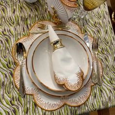 a place setting with gold trimmings and white plates