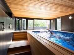 an indoor swimming pool with wooden flooring and walls that look like wood planks