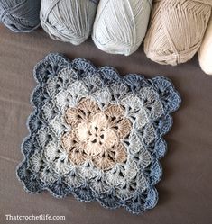 several balls of yarn sitting next to each other on top of a table with crocheted doily