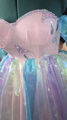 there is a pink dress with blue and purple sequins on the skirt,