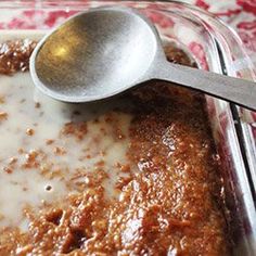 a glass dish filled with some kind of food and a silver spoon on top of it