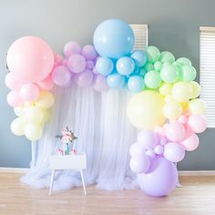 there is a rainbow balloon arch in the room