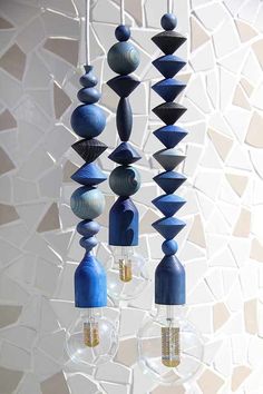 a chandelier made out of blue wood and glass bulbs hanging from it's sides