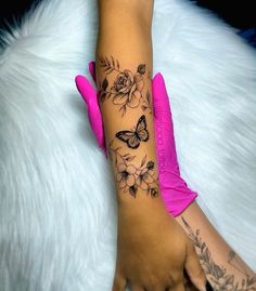 a woman's arm with flowers and butterflies on it