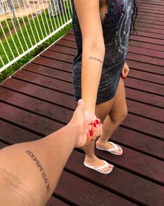 two people holding hands while standing on a deck