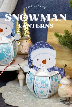 two snowman lanterns sitting on top of a table