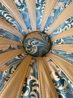 the inside of a blue and white umbrella with an intricate design on it's side