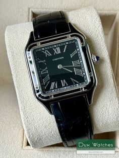 El Cartier Santos se introdujo en 1911 y se considera el primer reloj de pulsera para hombre. Fue diseñado por Louis Cartier y recibió su nombre en honor al pionero de la aviación Alberto Santos-Dumont, después de que usara los primeros prototipos del reloj durante sus vuelos. El diseño de caja cuadrada era único para la época y los tornillos expuestos alrededor del bisel sostenían el vidrio en su lugar y estaban destinados a parecerse a las patas de la Torre Eiffel. Combinado con un dial altame Vintage Cartier Watch With Chronometer, Vintage Cartier Watch With Rectangular Dial, Cartier Rectangular Analog Watch, Cartier Black Business Watch Accessories, Classic Black Cartier Watch Accessories, Classic Black Watch With Rectangular Dial, Modern Cartier Analog Watch, Cartier Black Business Watch, Classic Black Cartier Watches