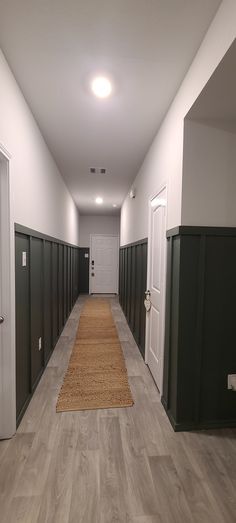 Grey green hallway board and batten Basement Long Wall Ideas, Board And Batten Height Hallway, Deep Green Board And Batten Wall, Long Office Hallway Decorating, Dark Board And Batten Entryway, Board And Batten Long Wall, Green Board And Batten Wall Dining Room, Dark Painted Board And Batten, Dark Board And Batten Hallway